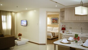 Une chambre d’hôtel moderne comprenant un espace de vie, un coin repas et une chambre à coucher.