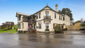 A two-story building with a balcony, a large window, and a door. - Bischoff Hotel (Waratah)