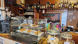 A bar area with a display of milkshakes, pastries, and jars of cookies. - Bischoff Hotel (Waratah)