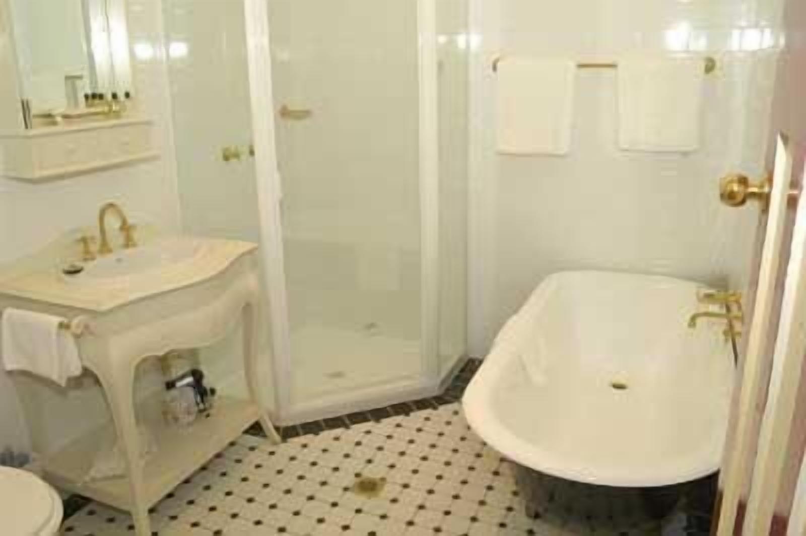 A bathroom with a sink, mirror, and bathtub.