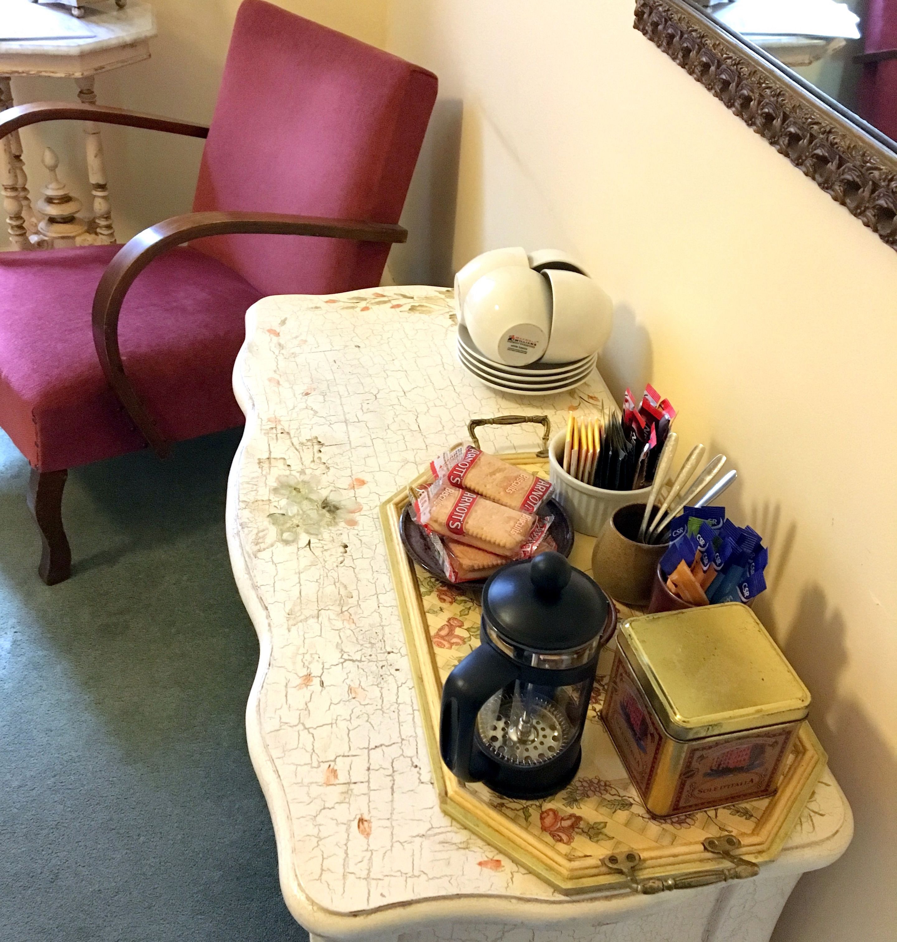 Une table avec un plateau de collations, une cafetière et une petite boîte.