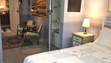 Une chambre à coucher comprenant un lit, une table de chevet, une chaise, un bureau et une armoire.