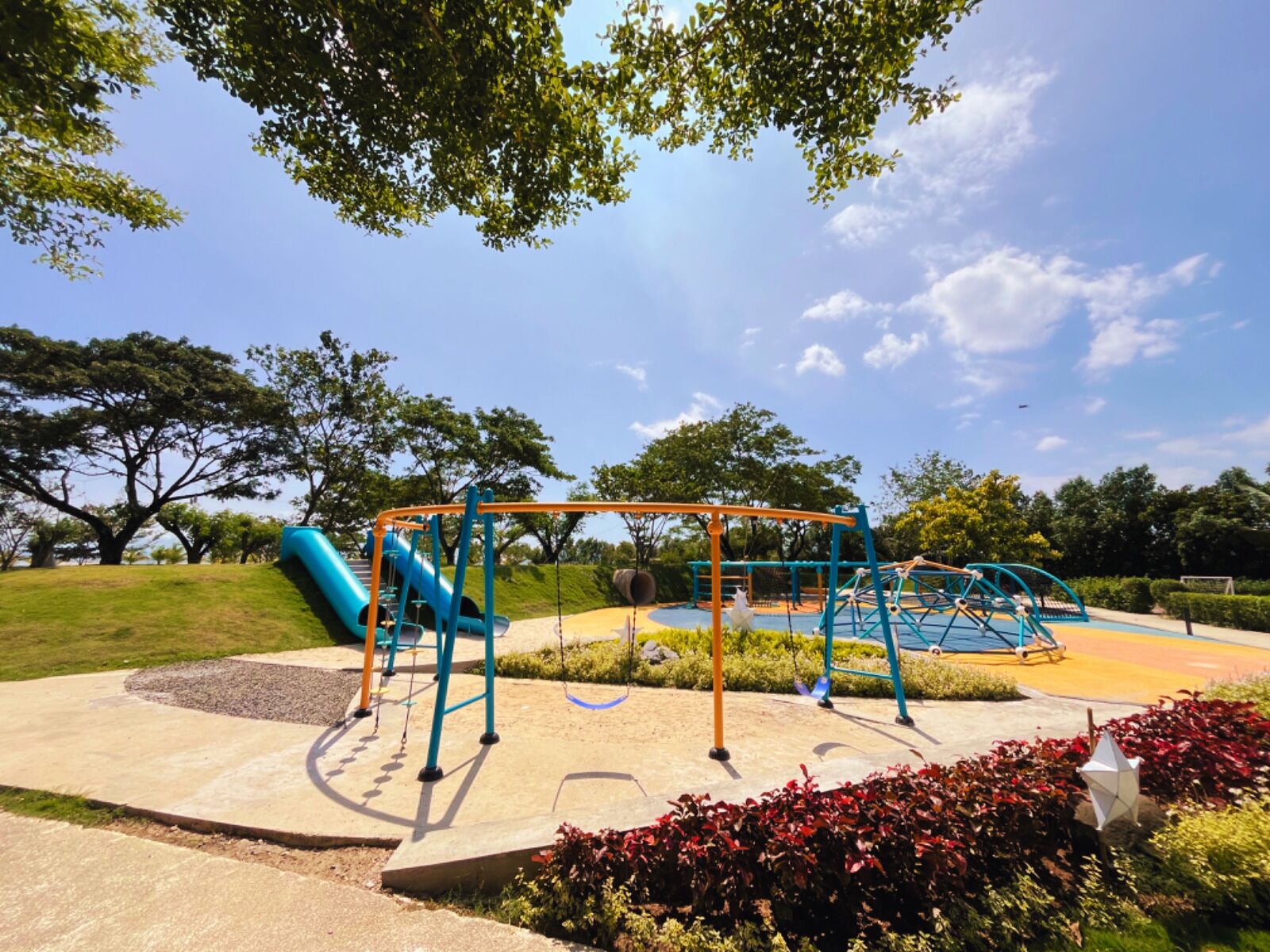 Un parque infantil con tobogán, columpios y estructuras para escalar.