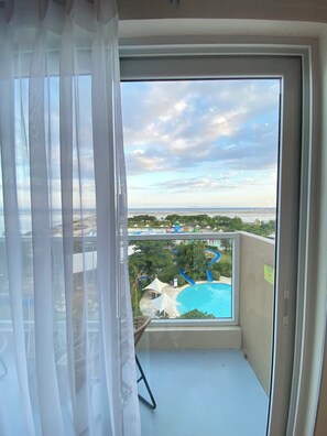 Un balcón con vistas despejadas a una piscina y un parque acuático.