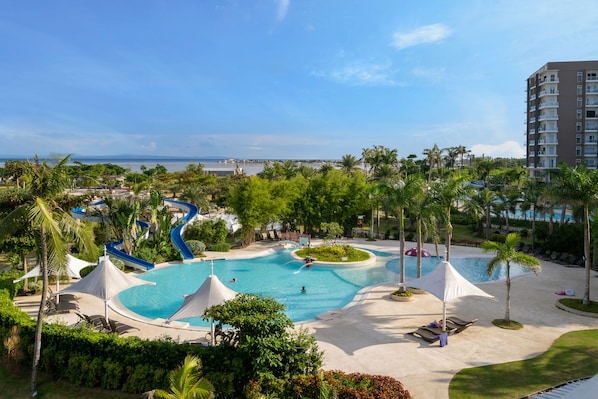 A resort pool area with multiple water slides, palm trees, and lounge chairs. - Solea Seaview Resort (Cordova)