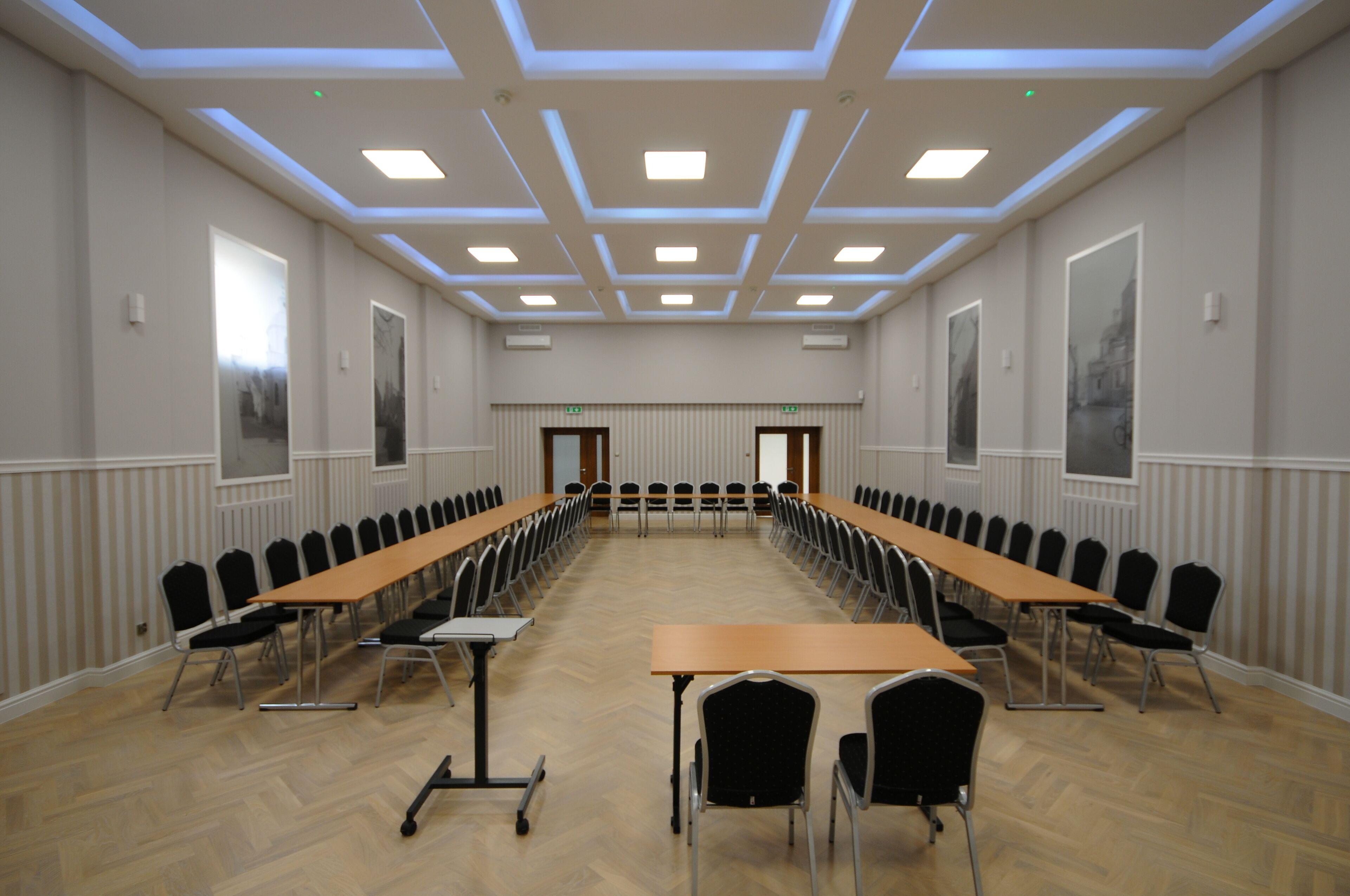 Ein Konferenzraum mit einem langen Tisch, Stühlen und einer Decke mit Einbuchtungslichtern.