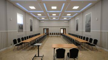 Ein Konferenzraum mit einem langen Tisch, Stühlen und einer Decke mit Einbuchtungslichtern.