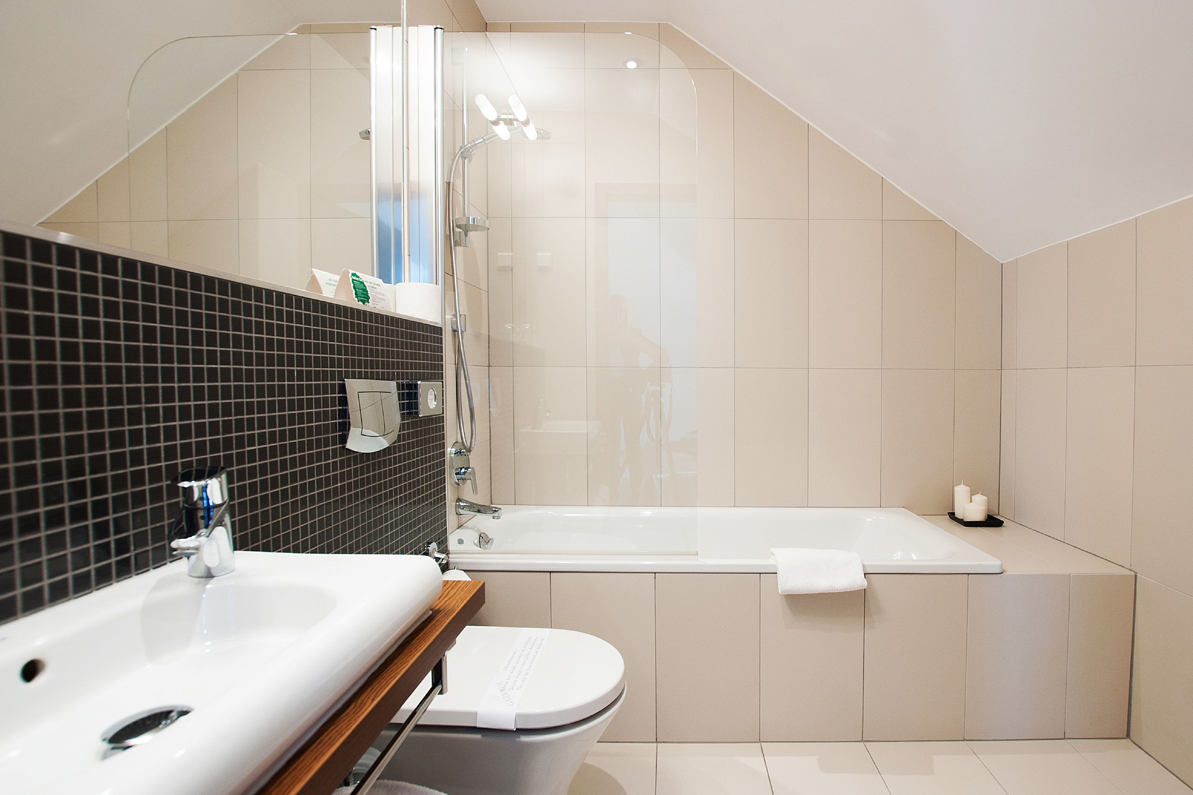 Un baño moderno con un lavabo blanco, un inodoro y una bañera.