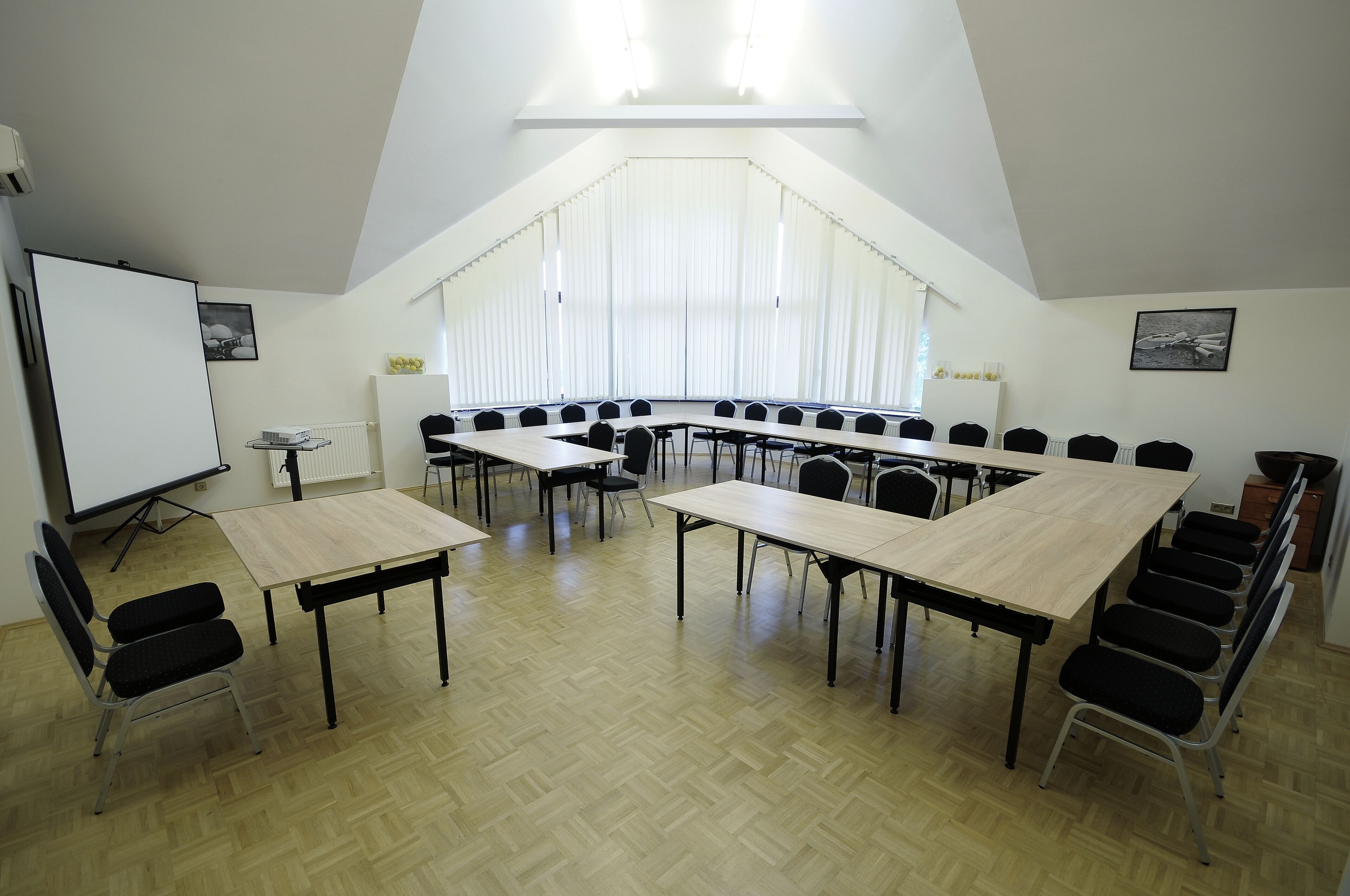 A conference room with a long table, chairs, a projector, and a whiteboard.