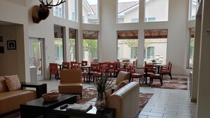 A spacious lobby with high ceilings, large windows, and a modern interior design.