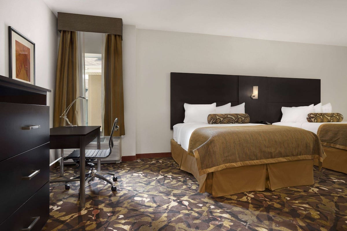Une chambre d’hôtel avec un lit, un bureau et une chaise.