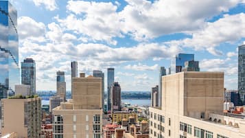 A cityscape with modern buildings, a river, and a clear sky.