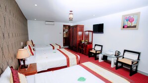 A hotel room with two beds, a desk with chairs, a television, and a painting on the wall. - Thanh Binh Trade Union Hotel (Da Nang)