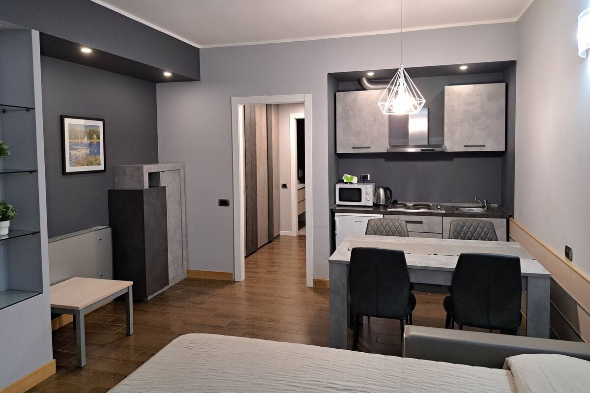 A modern kitchen with a dining area, a small refrigerator, and a microwave.