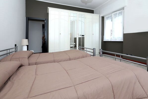 Une chambre à coucher avec un grand lit, une armoire et une fenêtre.