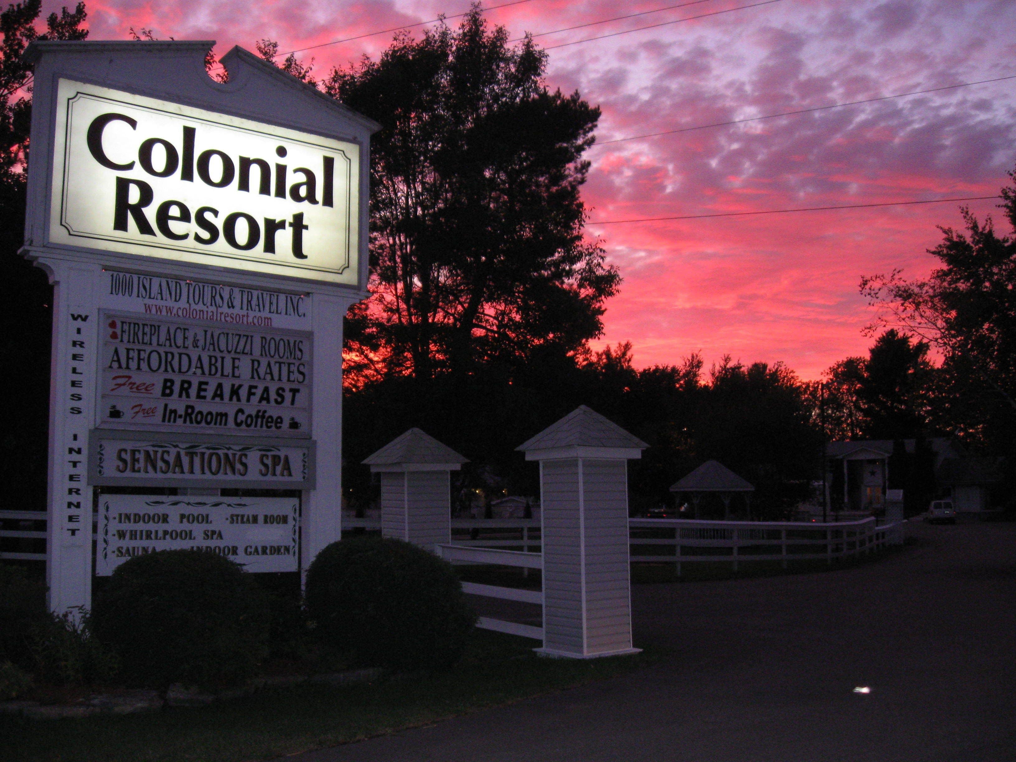 A sign for Colonial Resort advertising amenities like wireless internet, a fireplace, jacuzzi rooms, affordable rates, free breakfast, in-room coffee, and a sensations spa.