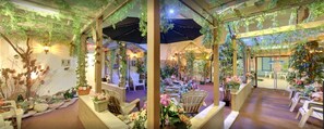 Un jardin intérieur agrémenté de pergolas en bois, d’espaces aménagés pour s’asseoir et de plantes en pot.