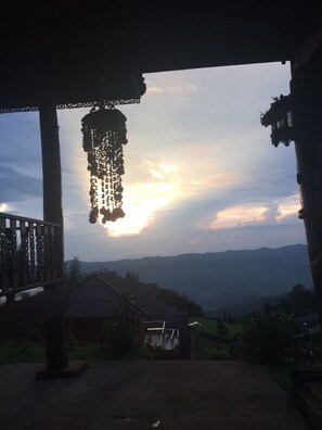 Un espace extérieur offrant une vue sur les montagnes lointaines et un coucher de soleil.
