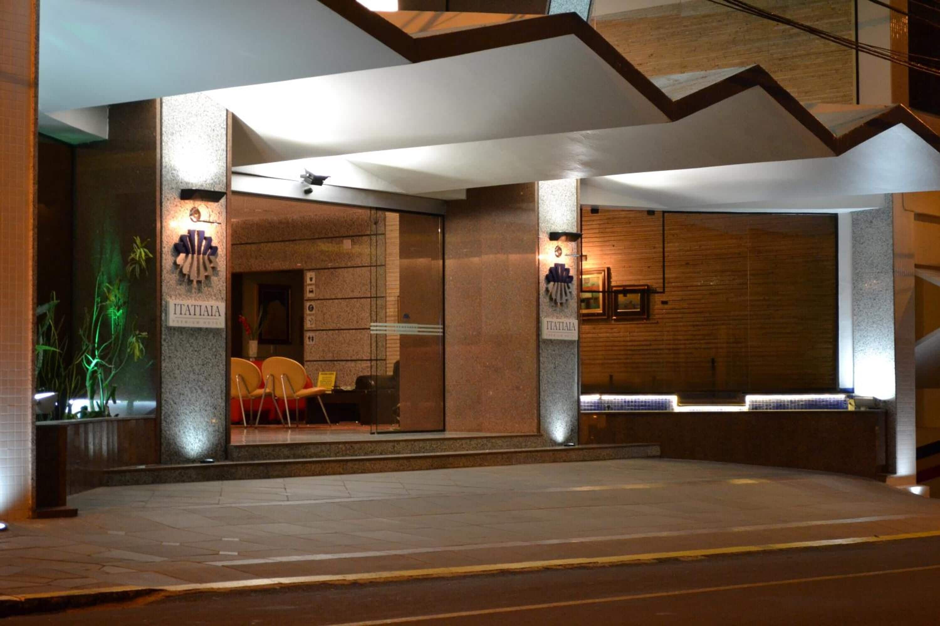 Une entrée d’hôtel moderne avec un comptoir de réception, un espace salon et un escalier menant à l’étage supérieur.