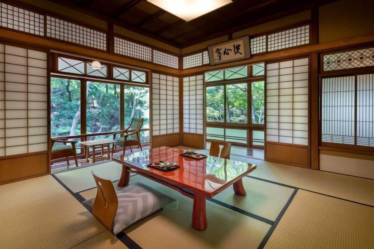 A traditional Japanese room with tatami flooring, a low table, and sliding doors.