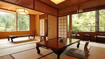 Une pièce de style japonais traditionnel, avec un sol recouvert de tatamis, une table basse et des portes coulissantes.