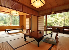 A traditional Japanese room with tatami flooring, a low table, and sliding doors.