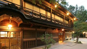 Un bâtiment japonais traditionnel, doté de plusieurs étages en bois et d’une galerie couverte.