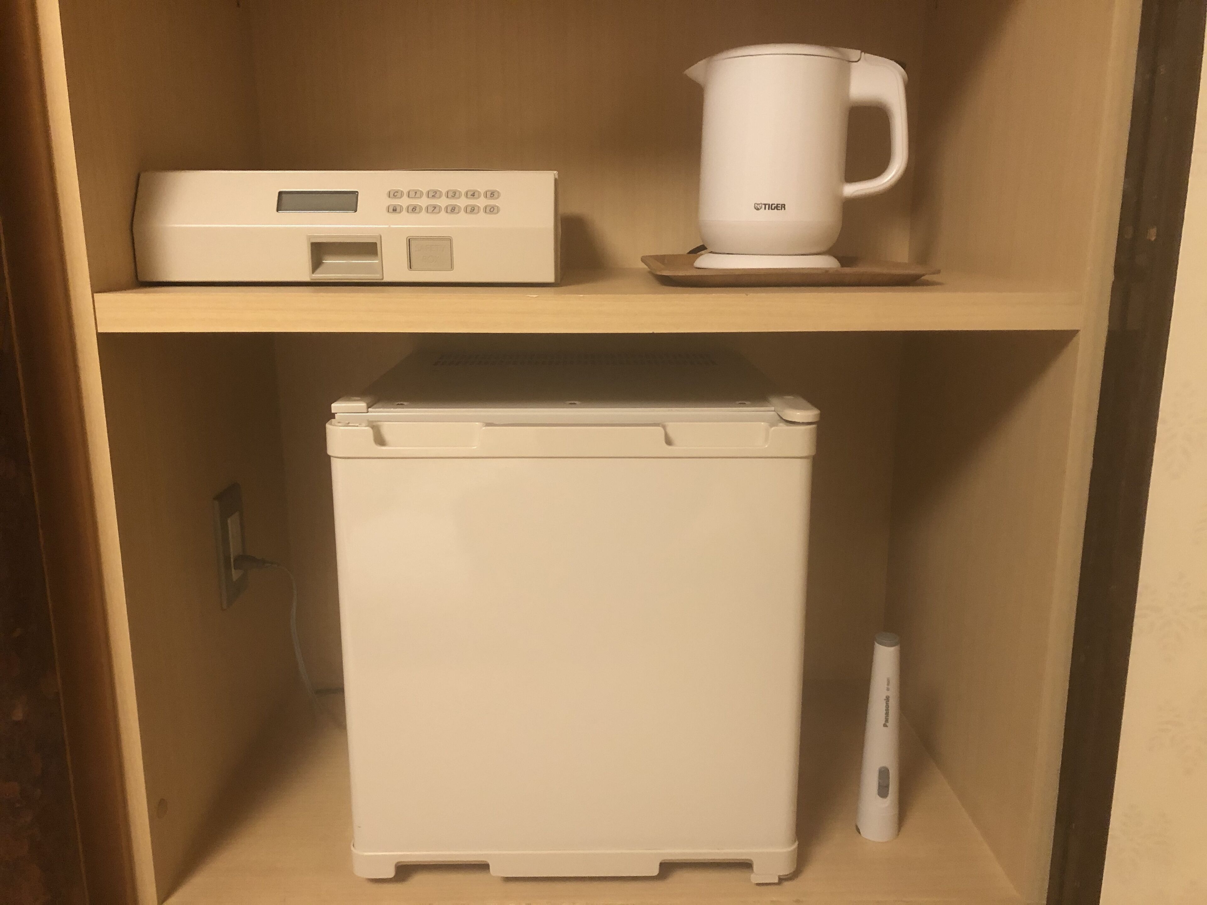 Une petite cuisine équipée d’une machine à café, d’une balance numérique et d’un réfrigérateur.