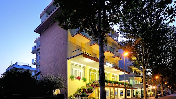 A multi-story hotel with a modern design, featuring balconies and a well-lit entrance. - Hotel Samoa (Rimini)