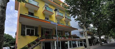A yellow building with "SAMOA" on the facade, a staircase, and a covered entrance area.