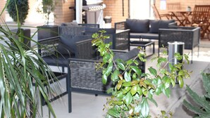 An outdoor seating area with wicker furniture and a grill. - Golden Harvest Motor Inn (Moree)