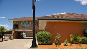 A two-story building with a brick facade, numbered 366, and a covered driveway. - Golden Harvest Motor Inn (Moree)