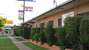 A motel with a signboard indicating a 4-star rating, a 24-hour check-in, and a 24-hour check-out service. - Golden Harvest Motor Inn (Moree)