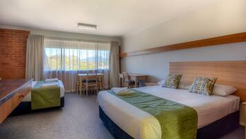 A hotel room with two beds, a desk, and a chair.