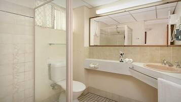 A bathroom with a toilet, sink, and mirror.