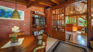 A wooden dining table with chairs, a picture frame, and a potted plant. - Pousada Monte Felice Recanto da Lua (Gramado)