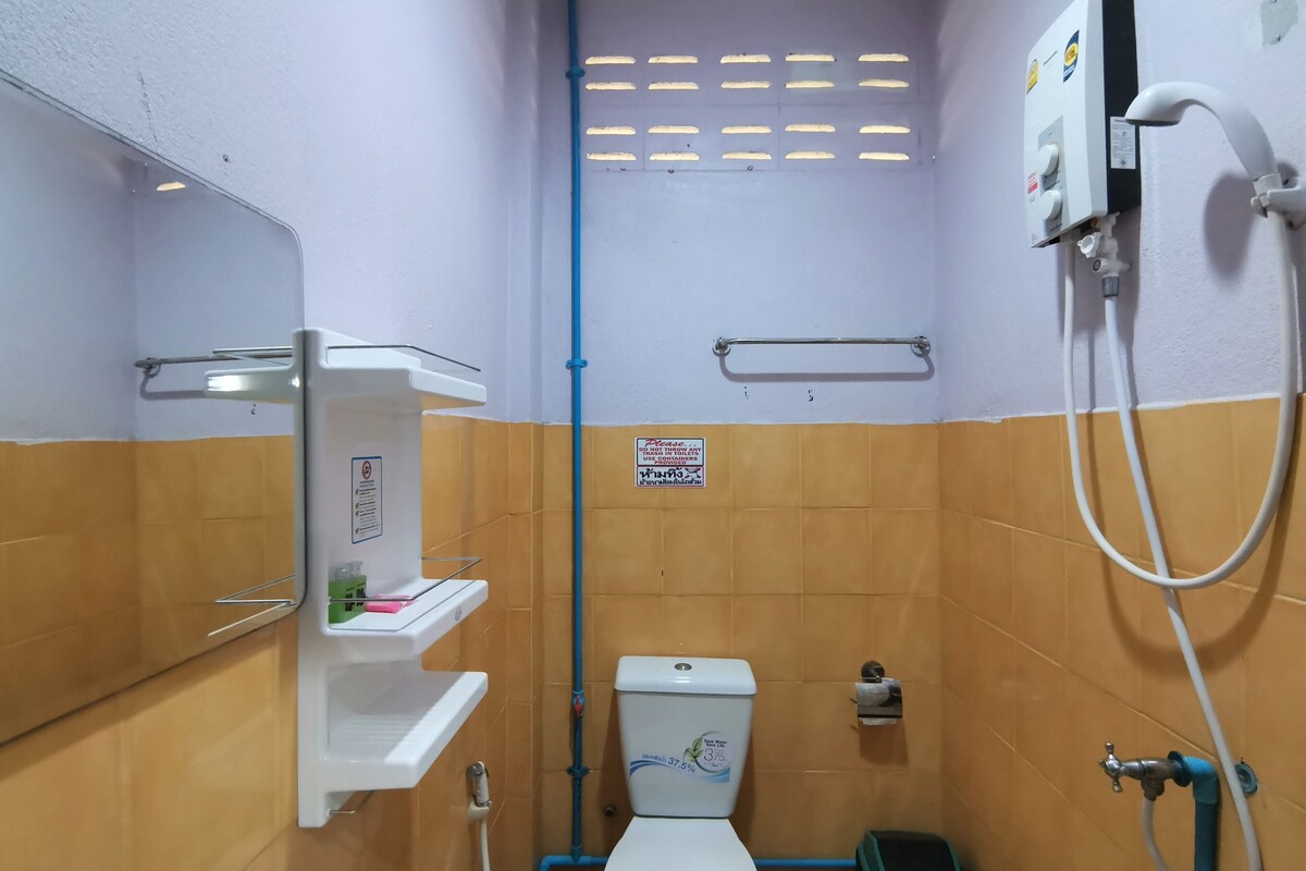 A small, compact bathroom with a toilet, a sink, and a shower.