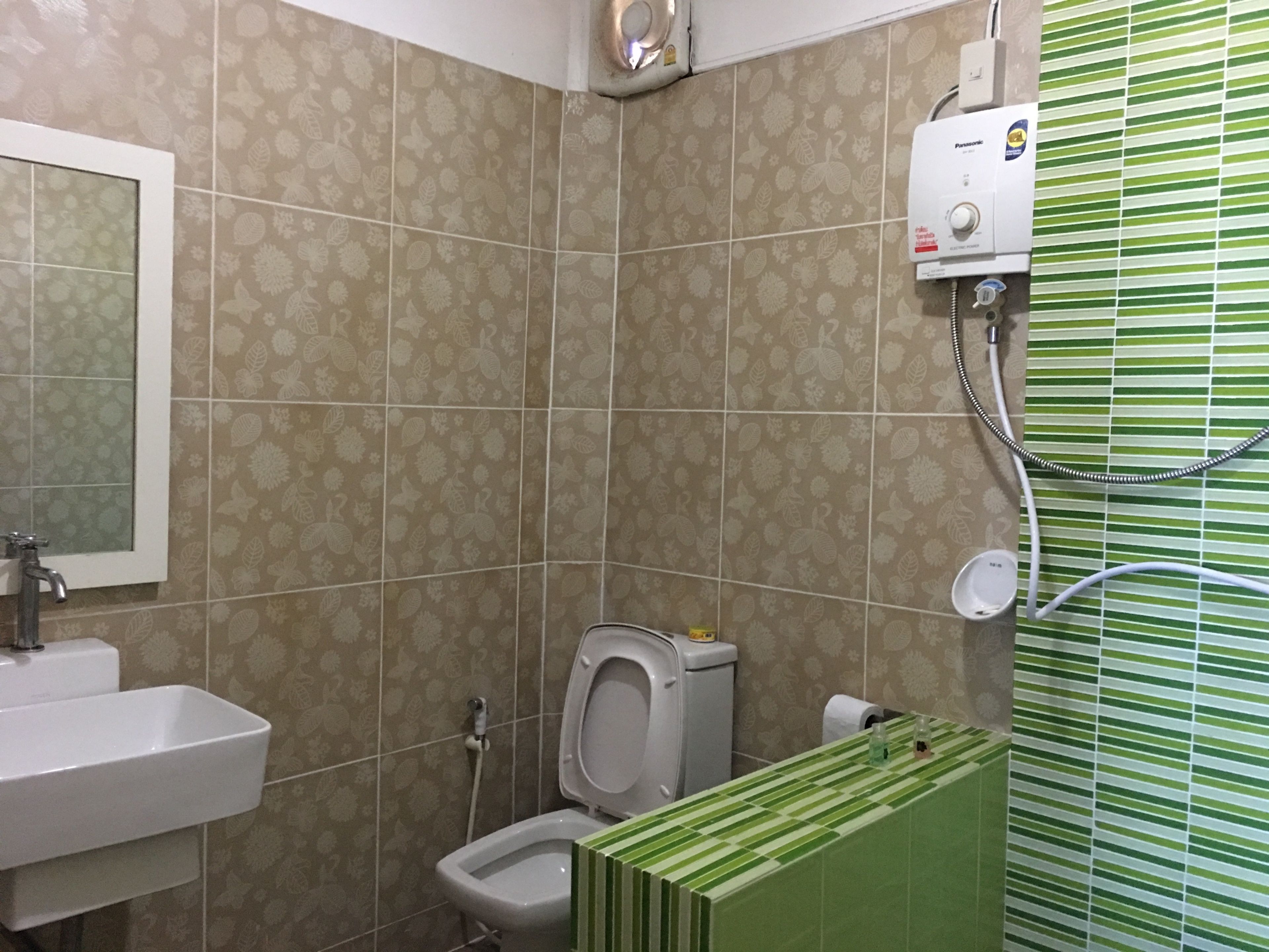 A bathroom with a toilet, sink, and shower.