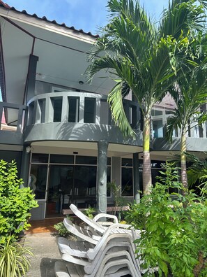 A building with a covered entrance, large windows, and a palm tree. - Lanta Garden Home (Ko Lanta)