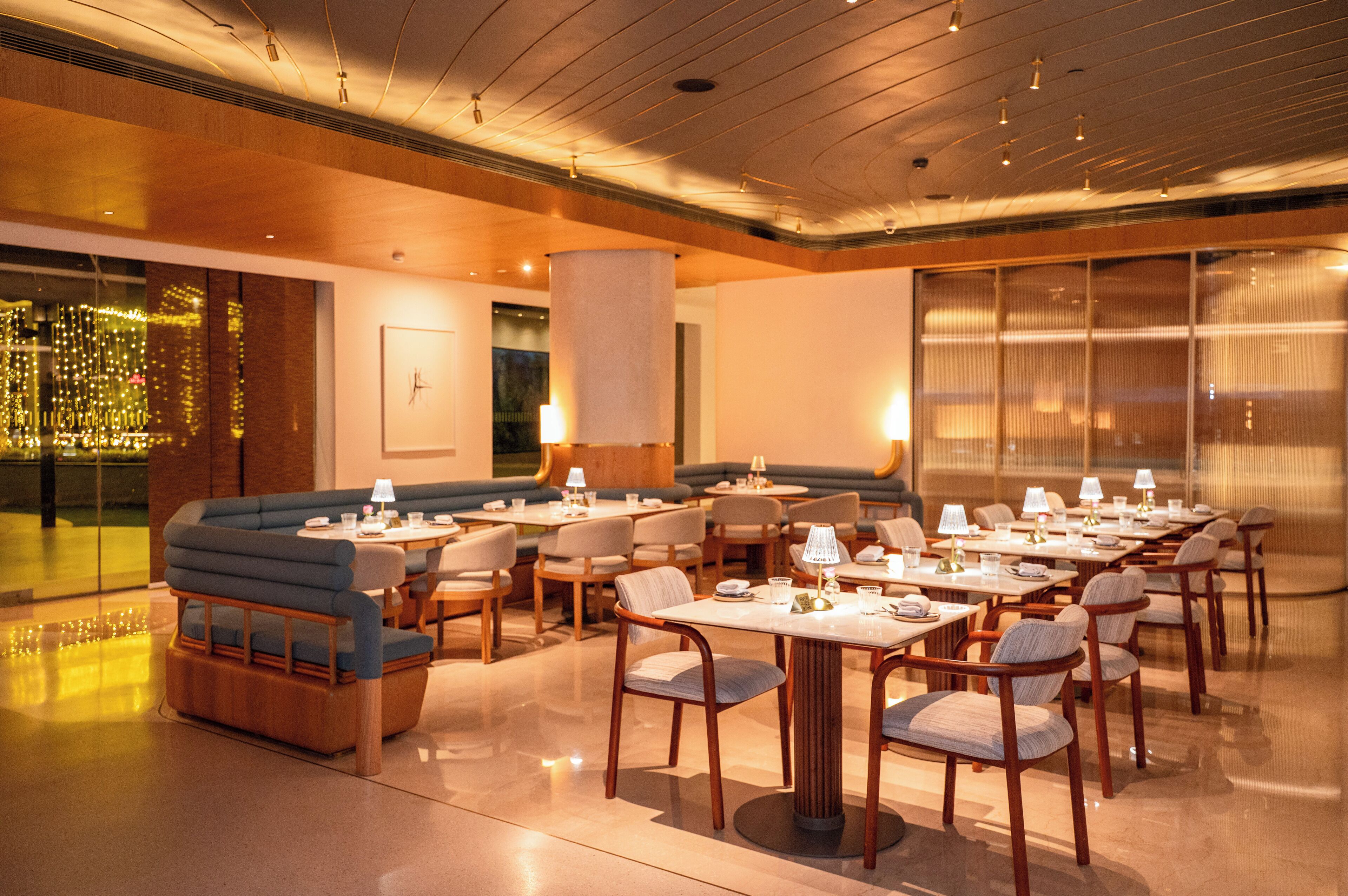 A modern dining area with booths and tables, wooden accents, and a large window.