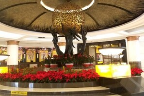 A lobby with a central fountain, potted plants, and a reception desk. - Garden Hotel Dongguan (Dongguan)