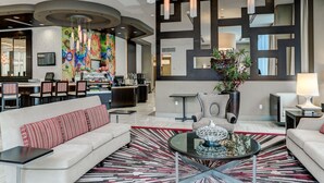 Um lobby moderno com balcão de recepção, área de estar e um painel decorativo.