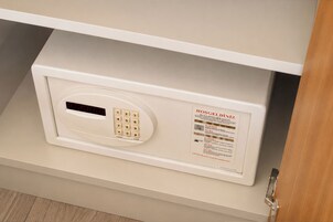Una cerradura electrónica con teclado blanco sobre un mueble beige, con una etiqueta en un idioma extranjero.