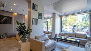 A modern interior with a sofa, a coffee table, and a potted plant. - May Park Hotel (Izmir)