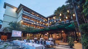 Un hotel de varios pisos con espacios de comedor al aire libre, un bar y un restaurante.