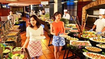 A buffet setup with various food items and staff serving.