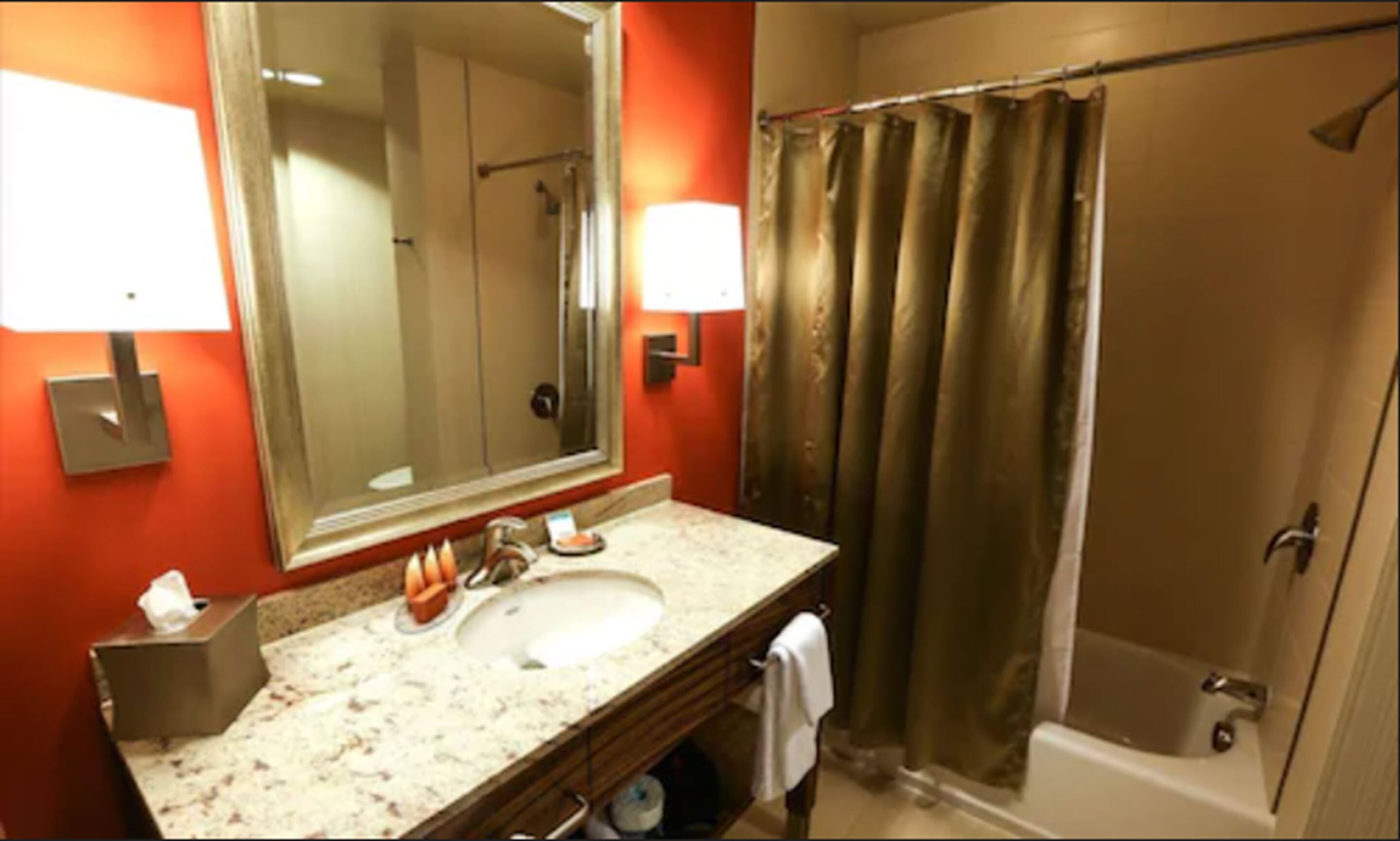 Un baño con lavabo, espejo, toallero y cortina de ducha.