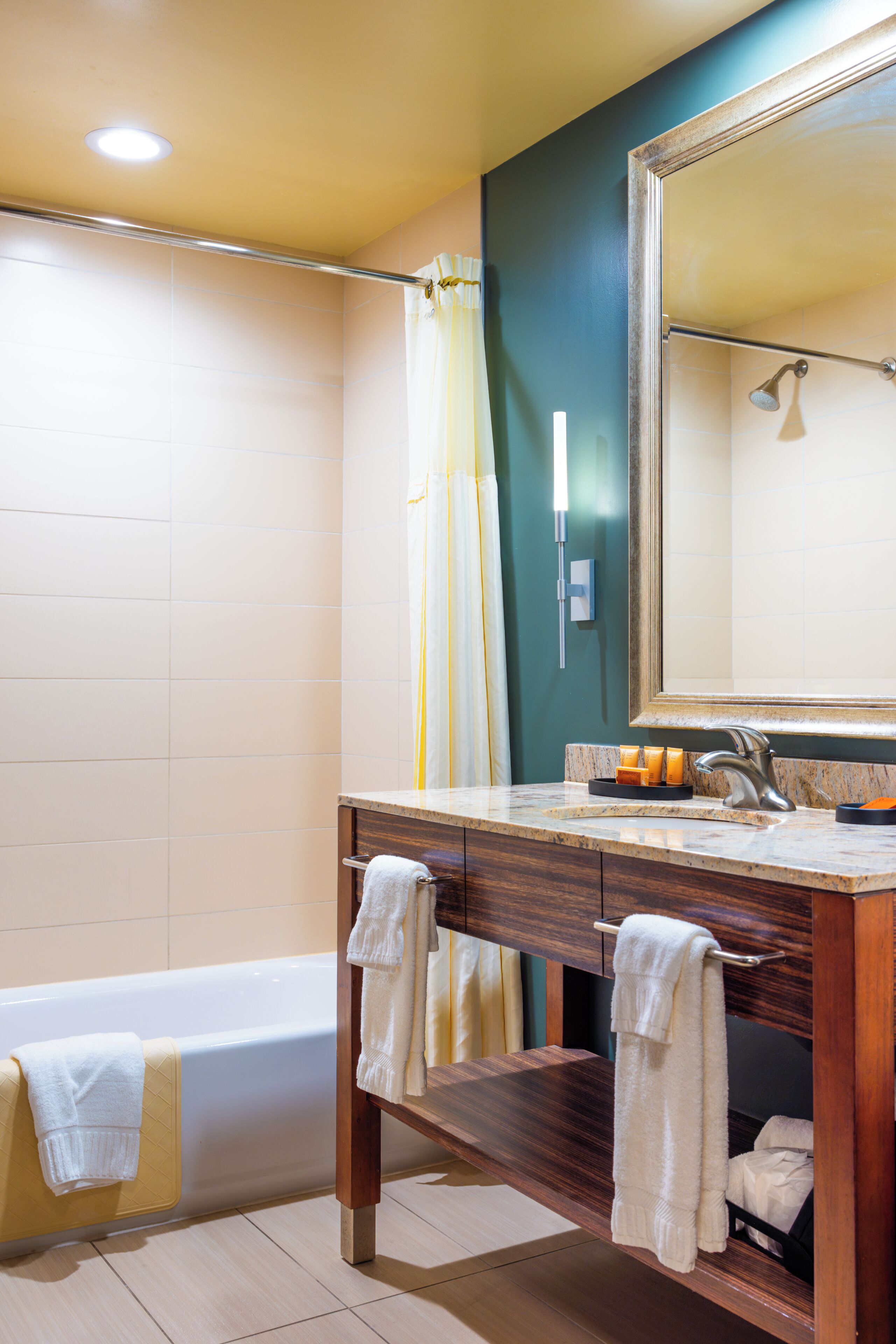 Un baño con bañera, tocador con espejo y zona de ducha.