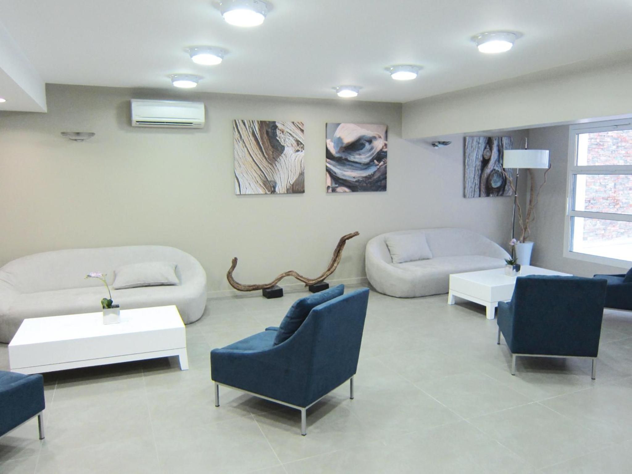 A modern living room with two sofas, a coffee table, and a blue armchair.