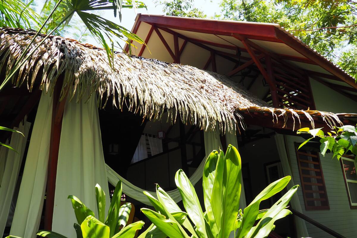 A traditional house with a thatched roof, wooden beams, and a white exterior.